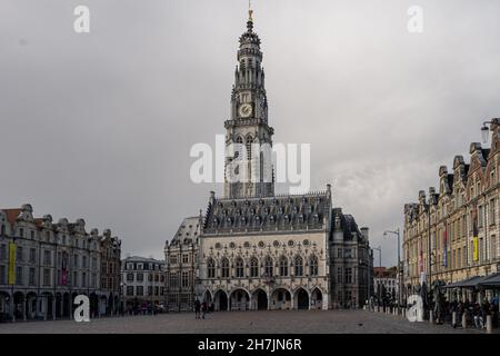 Arras, Frankreich - 4. November 2021: Marktplatz von Arras, Frankreich. Der Belfried von Arras, das zum UNESCO-Weltkulturerbe gehört, steht vor einem dunkelgrauen Himmel Stockfoto