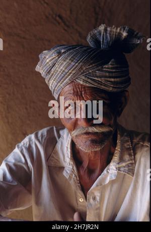 Ein sindhi Mann sitzt vor seinem Haus in Mithi, einem Dorf in der Wüste Tharparkar Region der Provinz Sindh in Pakistan. Juli 10, 2005. Stockfoto