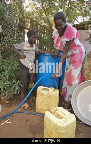 Ein junges Mädchen hilft ihrer Mutter beim Verkauf von Wasser in Juba, der Hauptstadt des Südsudan. Sie verdienen 10 bis 15 sudanesische Pfund pro Tag aus ihrem Geschäft. De Stockfoto
