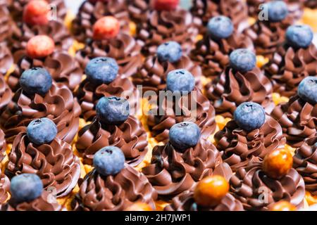 Cupcakes mit Creme verziert mit Beeren. Konzept der Süßigkeitenbar für Geburtstagsfeier, Hochzeit, 8. märz, Muttertag, Valentinstag. Stockfoto