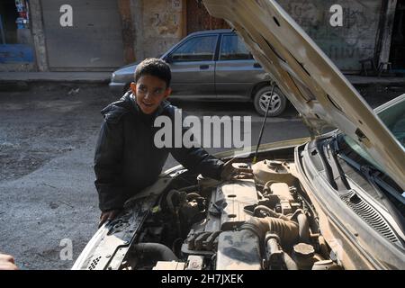 Aleppo, Syrien, 21. November 2021, syrische Kinder, die durch den Krieg gezwungen wurden, die Schule zu verlassen und sich harten Berufen anzuschließen, um ihren Familien zu helfen Stockfoto