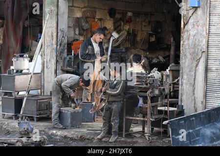 Aleppo, Syrien, 21. November 2021, syrische Kinder, die durch den Krieg gezwungen wurden, die Schule zu verlassen und sich harten Berufen anzuschließen, um ihren Familien zu helfen Stockfoto