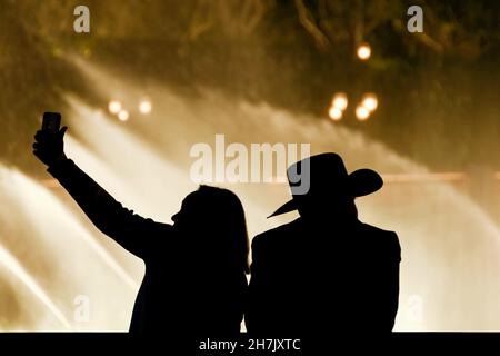 Las Vegas, Nevada, USA - 2019. Februar: Ein Mann mit Cowboyhut und eine Frau mit einem Selfie, das gegen die Springbrunnen im Bellagio Hotel geschiltert wurde Stockfoto