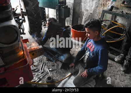 Aleppo, Syrien, 21. November 2021, syrische Kinder, die durch den Krieg gezwungen wurden, die Schule zu verlassen und sich harten Berufen anzuschließen, um ihren Familien zu helfen Stockfoto