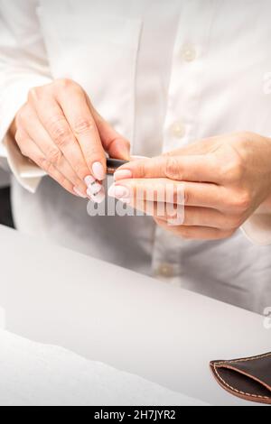 Professioneller Manikurist, der Werkzeuge für die Nagelpflege der Kunden vorbereitet Stockfoto