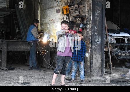 Aleppo, Syrien, 21. November 2021, syrische Kinder, die durch den Krieg gezwungen wurden, die Schule zu verlassen und sich harten Berufen anzuschließen, um ihren Familien zu helfen Stockfoto