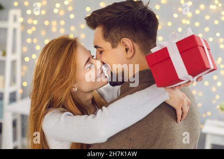 Nahaufnahme von zwei Liebhabern, die sich nach dem Austausch von Geschenken am Valentinstag umarmen und küssen. Stockfoto