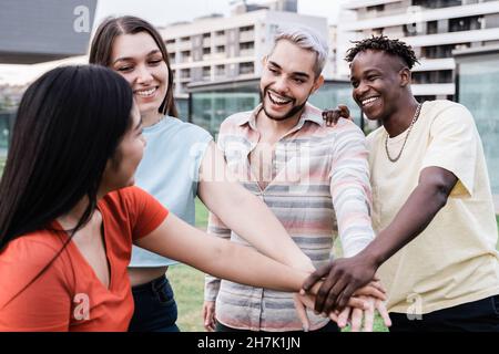 Junge verschiedene Gruppe von Menschen feiern zusammen Stapeln Hände im Freien - Fokus auf Homosexuell Mann trägt Make-up Stockfoto