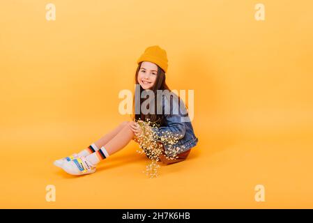 Porträt eines schönen und selbstbewussten Mädchen zeigt Emotionen isoliert auf gelb, Studio Stockfoto