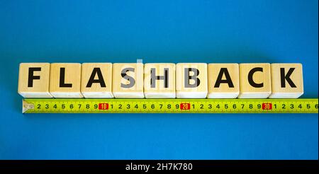 Flashback-Symbol. Das Konzeptwort Flashback auf Holzwürfel. Gelbes Lineal. Schöner blauer Tisch, blauer Hintergrund. Business- und Flashback-Konzept. Cop Stockfoto