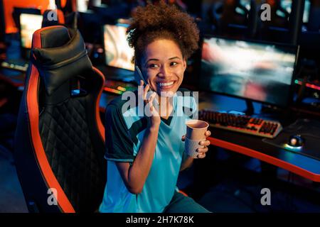 Schöne weibliche Gamer sitzt auf Gaming-Stuhl im Cyber-Club Stockfoto