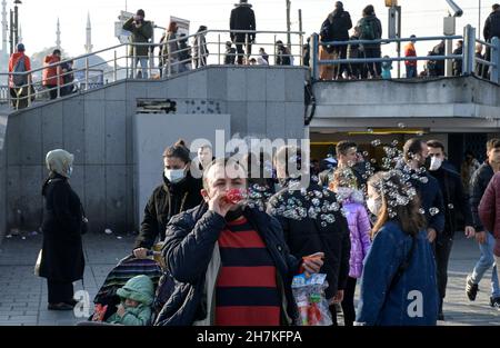 TÜRKEI, Istanbul, Eminönü Fährstation, Corona Pandemie, Menschen mit Gesichtsmasken, Seifenblasenverkäufer / TÜRKEI, Istanbul, Stadtteil Eminönü Fähranleger, Corona Pandemie, Passanten mit Masken Stockfoto