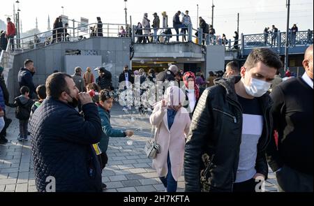 TÜRKEI, Istanbul, Eminönü Fährstation, Corona Pandemie, Menschen mit Gesichtsmasken, Seifenblasenverkäufer / TÜRKEI, Istanbul, Stadtteil Eminönü Fähranleger, Corona Pandemie, Passanten mit Masken Stockfoto