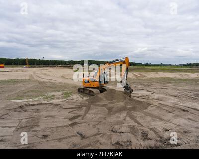 VIANEN, NIEDERLANDE - 05. Jun 2019: Der Orange Bagger auf einer großen Baustelle unter dem wolkenlosen Himmel Stockfoto