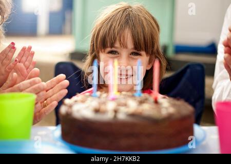 Glückliches Mädchen feiert Geburtstag mit der Familie Stockfoto