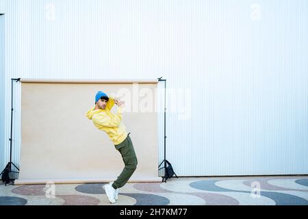 Junge männliche Tänzerin bricht beim Balancieren auf den Zehen im Hintergrund Stockfoto