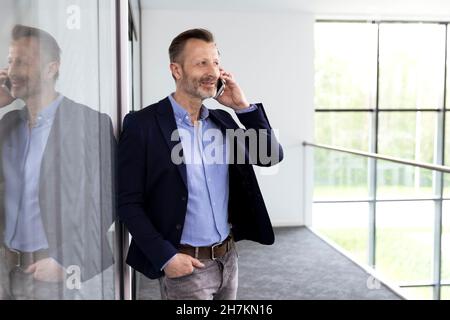 Porträt eines französischen Bulldoggen-Welpen, der im Herbst auf der Parkbank sitzt Stockfoto