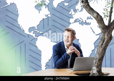 Geschäftsmann mit Hand am Kinn Blick auf laptop Stockfoto
