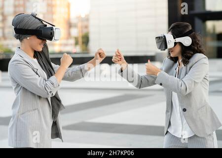 Professionelle Frauen, die beim Tragen einer VR-Brille gestikulieren Stockfoto