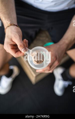 Männlicher Athlet, der nach dem Sport Proteinshake macht Stockfoto