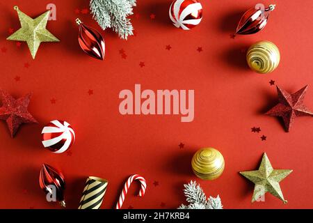 Vintage Weihnachten Hintergrund mit roten und goldenen Kugeln Dekorationen, Sterne, Zuckerrohr, Tannenzweige im Schnee. Vorlage für Weihnachtskarten im Retro-Stil. Stockfoto