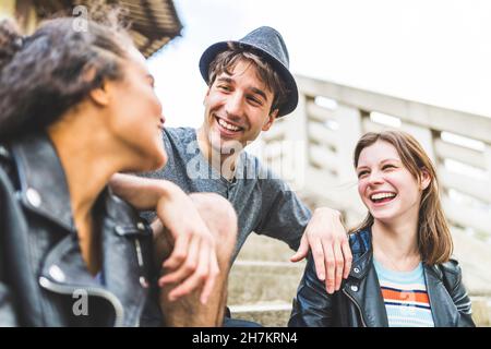 Glückliche Freunde, die sich im Park unterhalten Stockfoto