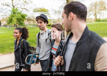 Multirassische Gruppe junger Freunde, die im Park zusammen spazieren Stockfoto