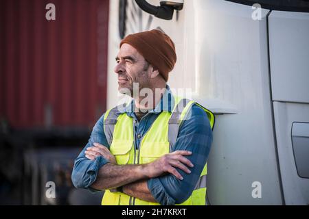 Nachdenklicher männlicher Fahrer mit gekreuzten Armen vor dem LKW Stockfoto