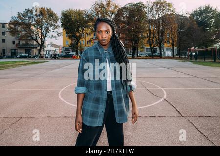 Junge Frau mit locs Frisur auf dem Sportplatz Stockfoto