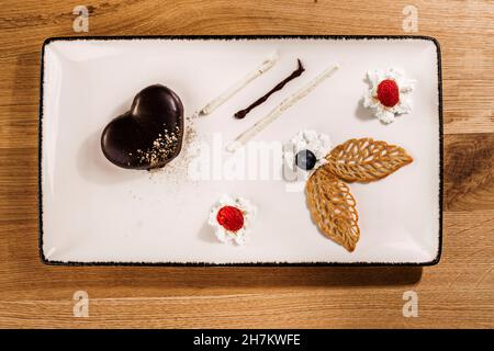 Studio Schuss Tablett mit fein präsentiert Schokoladenkuchen mit Obst und Schlagsahne Ergänzungen Stockfoto