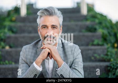 Ernsthafter Geschäftsmann, der mit der Hand am Kinn nachdenkt Stockfoto