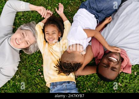 Lächelnde Familie, die sich auf Gras ausruhen Stockfoto