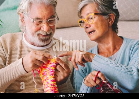 Frau lehrt Mann stricken Wolle mit Nadel zu Hause Stockfoto