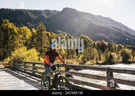Mann mit Helm Mountainbiken auf der Brücke Stockfoto