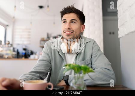 Nachdenklicher Geschäftsmann, der aus dem Cafefenster schaut Stockfoto