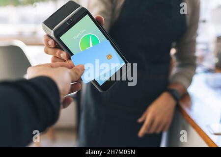 Der Kellner zeigte auf den Bildschirm des Kreditkartenlesers im Café Stockfoto