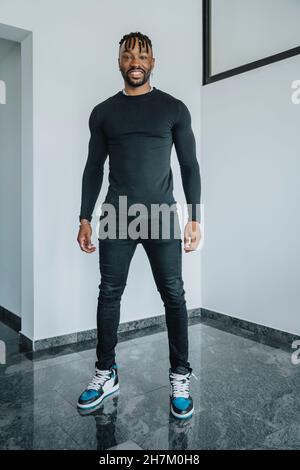 Junger lächelnder Mann steht Stockfoto