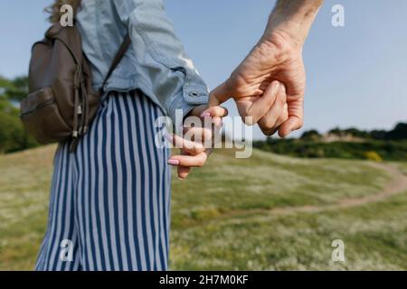 Frau mit rosafarbenem Finger und Freund, der auf der Wiese läuft Stockfoto