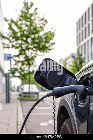 Steckdose zum Aufladen des Fahrzeugs an der Ladestation für Elektrofahrzeuge Stockfoto