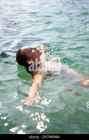 Frau, die am Wochenende im Meer schwimmend war Stockfoto