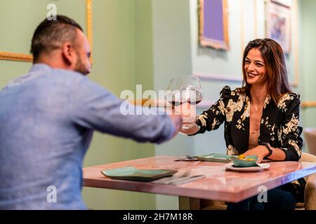 Glückliches Paar, das Weingläser im Restaurant toasting Stockfoto