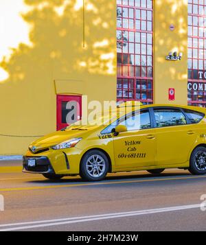 Gelbes Taxi auf der Straße der Innenstadt von Granville Island in Vancouver BC. Stockfoto