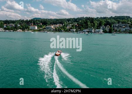 Österreich, Kärnten, Velden am Worther See, Luftbild des Motorbootes, das über das türkisfarbene Wasser des Worthersees wacht Stockfoto