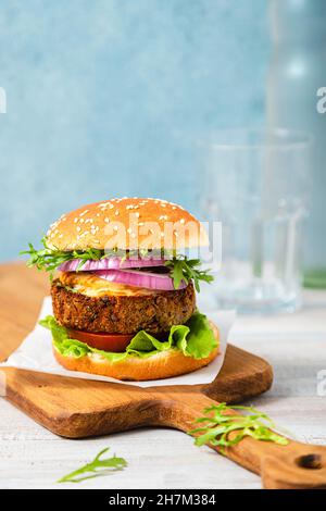 Burger-Sandwich mit Gemüse auf dem Tisch serviert Stockfoto