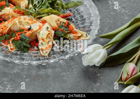 Dünne Pfannkuchen mit Kaviar und Lachs, zu Rollen gerollt Stockfoto