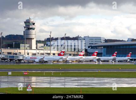 Flughafen Zürich ATC und Terminal mit Swiss Airlines Flugzeugen, die bei Regenwetter geparkt sind. Flugsicherungsturm des Flughafens Kloten in Swizterland. Stockfoto