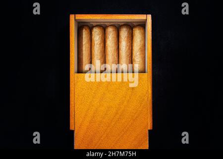 Schachtel mit kubanischen Zigarren auf einem schwarzen Tisch im Dunkeln. Teure Premium-Zigarren als Geschenk. Stockfoto