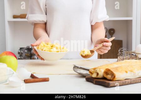 Frau bereitet Apfelstrudel am Tisch in der Küche vor Stockfoto