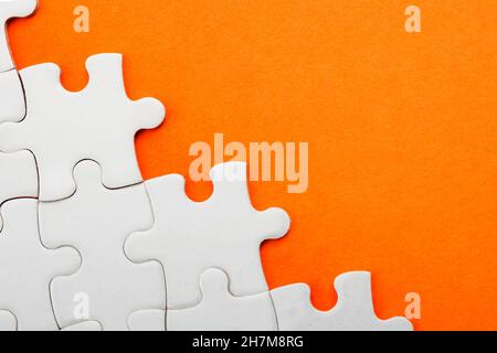Puzzle-Stücke und Business-Konzept mit einem Rand gemacht Von Puzzleteilen auf buntem hellorangefarbenem Hintergrund mit Kopie Platz Stockfoto