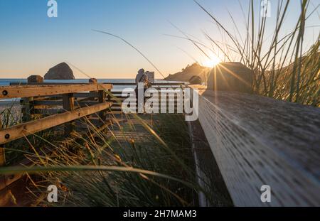 Eine Person, die den Sonnenuntergang und das ruhige Wetter im Cape Kiwanda State Natural Area in der Nähe von Pacific City, Oregon, USA, genießt Stockfoto